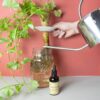 Botanopia organische plantenvoeding in een bruin flesje met pipetje met een gieter en een plant