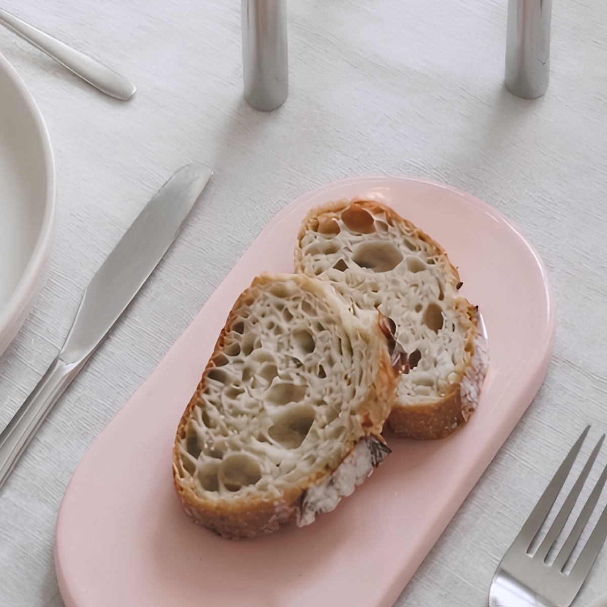 PLAYST ovaal roze bordje van 19,6 bij 9,8 cm met twee stukjes brood erop