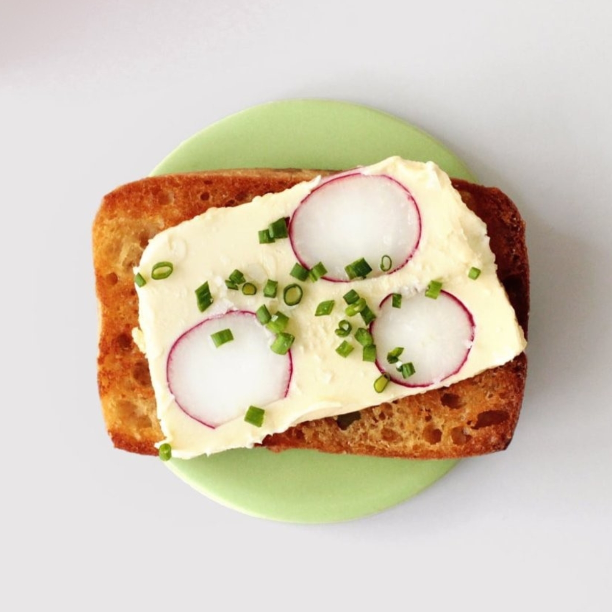 PLAYTS bordje rond in de kleur creme met toast op het bordje
