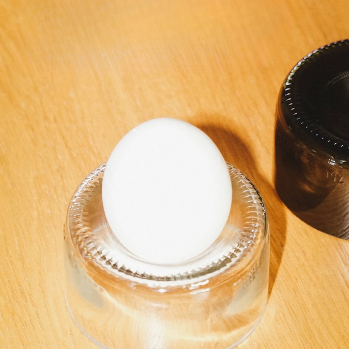 Rebottled eierdop van clear glas op tafel met ei er in