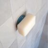 Soapi magnetische zeephouder tegen de muur geplakt met zeep eraan